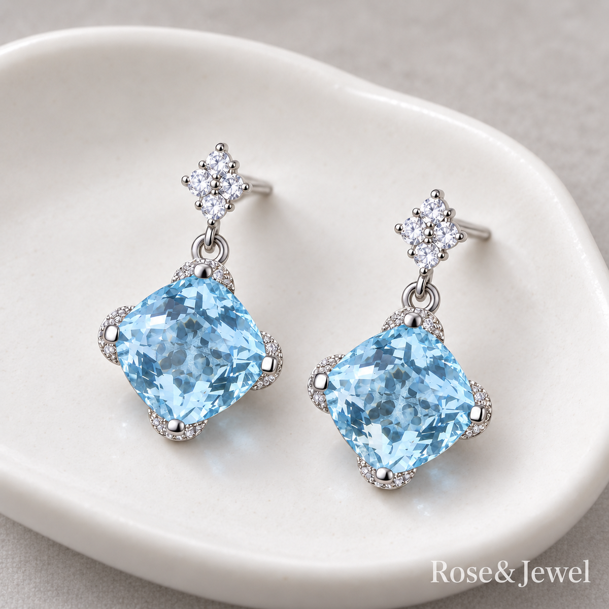 Light blue earrings resting naturally on an ivory dish
