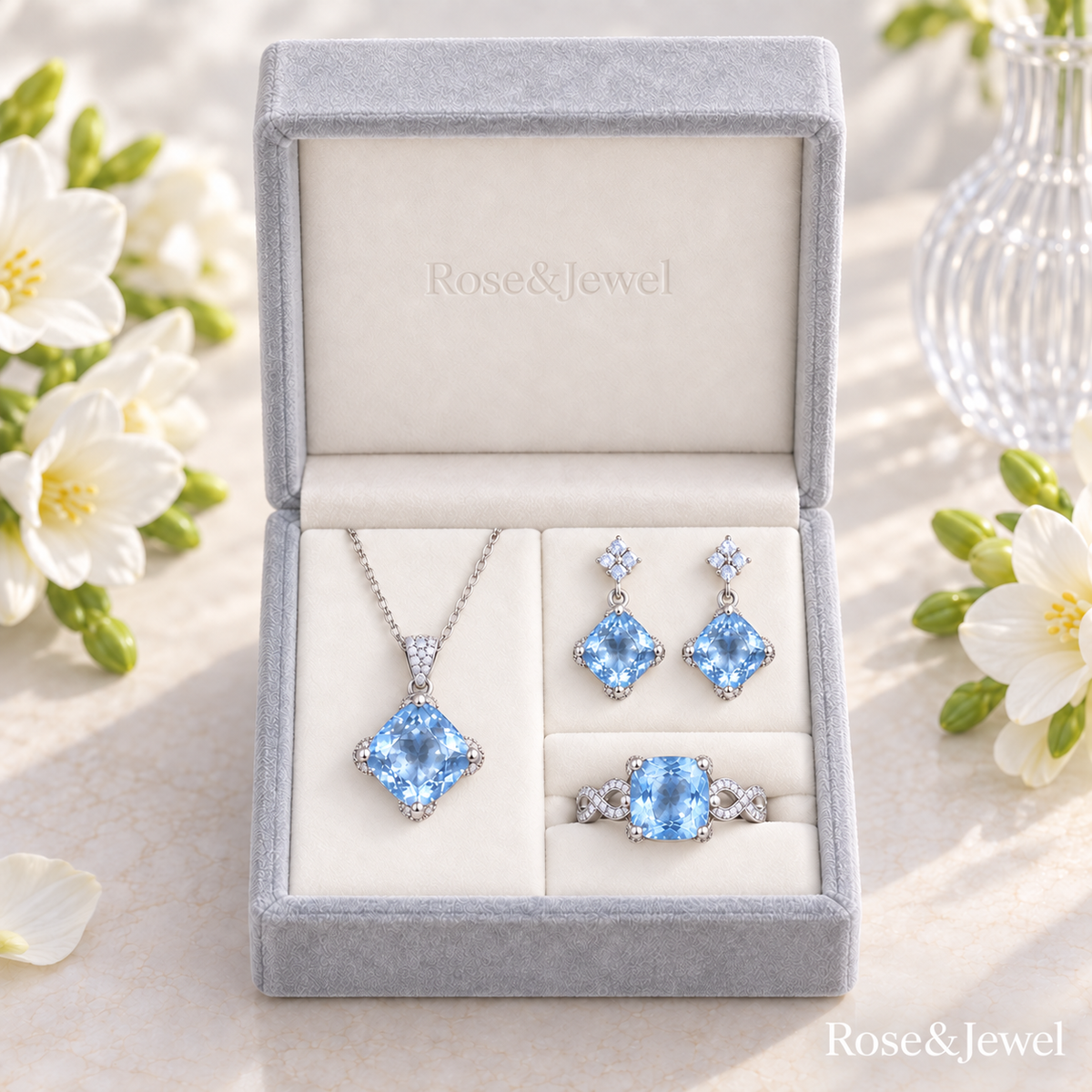 Light blue jewelry set in a grey box with a cushion square ring